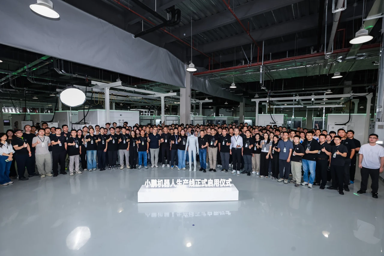 XPENG staff and IRON at the humanoid production-line commissioning event.